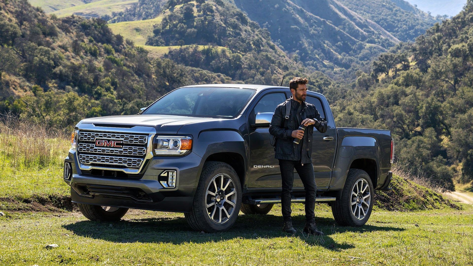 man standing besides GMC car